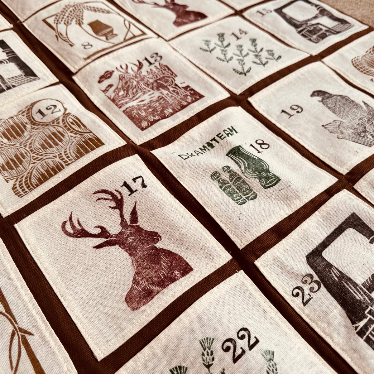 A decorative fabric advent calendar with Scottish-themed designs.